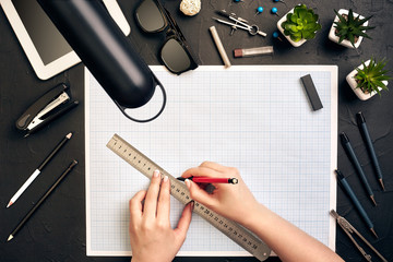 Office desk background hand with pen writing construction project ideas concept, With tablet, drawing equipment and lamp. View from above