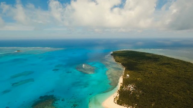 Aerial view of beautiful tropical island Daco with white sand beach. View of a nice tropical beach from the air. Beautiful sky, sea, resort. Seascape: Ocean and beautiful beach paradise. Philippines