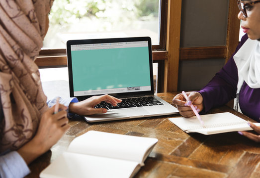 Islamic Women Discussing And Using Laptop For Working