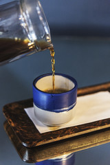 Black coffee in a small blue cup