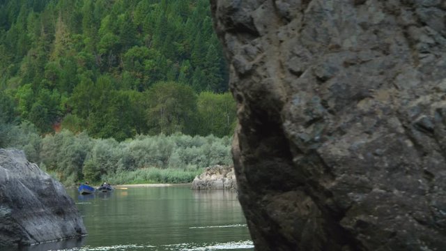 Floating close past a rock to reveal drift boats approaching on the Rogue River, Oregon