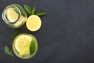 Fototapeta Fresh homemade lemonade with mint leaves, photographed overhead on slate (Selective Focus, Focus on the top of the lemonade) obraz