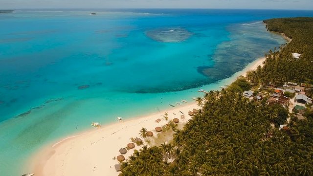Aerial view of beautiful tropical island Daco with white sand beach. View of a nice tropical beach from the air. Beautiful sky, sea, resort. Seascape: Ocean and beautiful beach paradise. Philippines