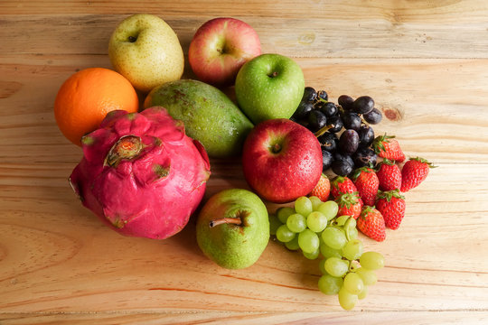 Set of different fruits on wooden table.