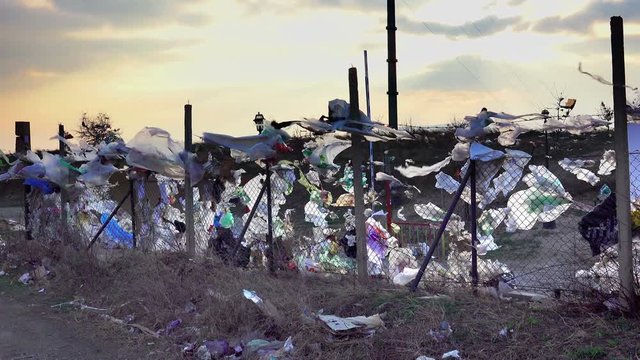 huge landfill with plastic bags against sunset