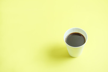 The hot coffee which was in the paper cup.  紙コップに入ったホットコーヒー　黄色背景