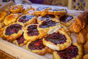 Close-up of fresh delicious buns with a berry, cowberry in a showcase in a bakery