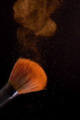 cosmetic brush with golden powder explosion
