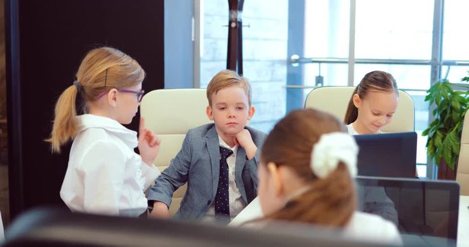 Girl businesswoman reports to her director a business plan on the promotion of the company. Business children at a meeting