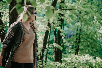 Slender blonde rests on tree trunk