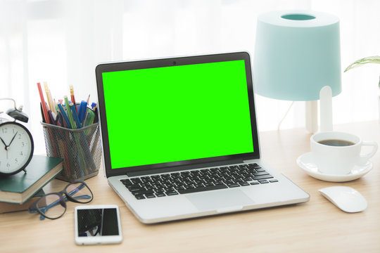 Mockup image of laptop with blank green screen.