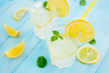 Refreshing drinks for summer, cold  lemonade juice with sliced fresh lemons - obrazy, fototapety, plakaty