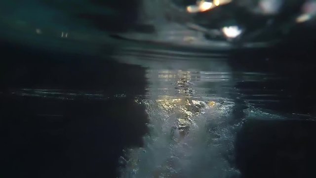 Man Jumps in swimming pool water at Sunset through the sun in slow motion. 1920x1080