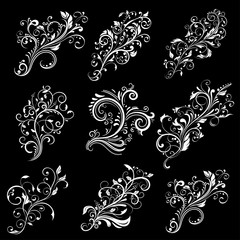 Floral decorative elements. White designs on black background
