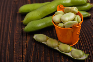 fresh broad beans on a rustic background