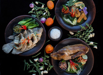 Many various dishes top view. Fish, duck, chiken on dark background