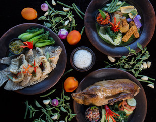Many various dishes top view. Fish, duck, chiken on dark background
