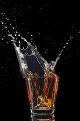 Isolated shot of whiskey with splash on black background