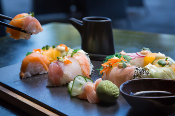 Sushi set with hand holding chopstick to eat Sushi