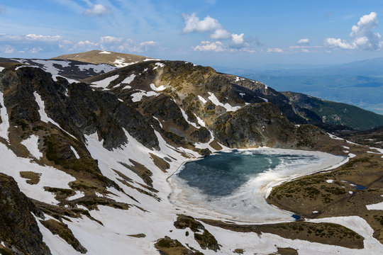 High angle view to the frozen waters of Bubreka or Babreka lake (kidney shaped lake) - one of the popular Seven Rila Lakes, Rila mountains, Bulgaria