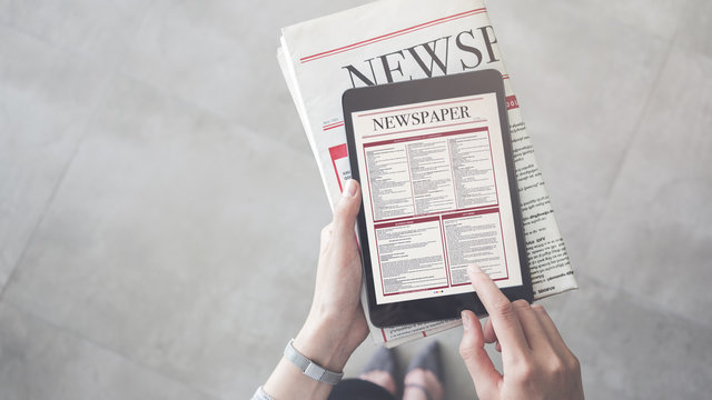 Person holding and reading news from tablet