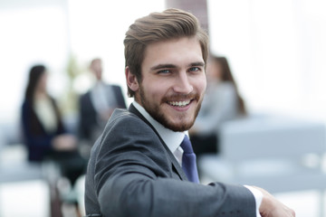 Successful business man standing with his staff in background at