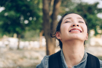 Close up young Asian woman in nature take a deep breath feeling fresh.