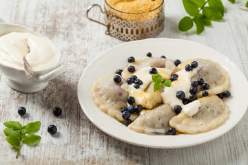 Delicious dumplings with fresh blueberries served with whipped cream and sugar or sauce.