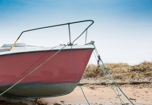Bow of sail yaght moored at low tide
