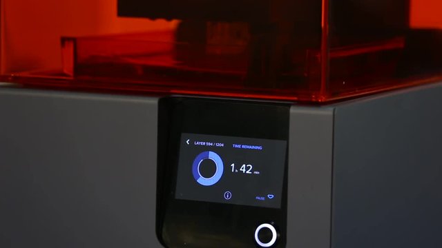 A 3d printer in the laboratory prints a structure from a photopolymer. On the display the process indicator and the number of layers