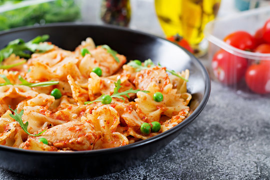 Farfalle pasta with chicken fillet, tomato sauce and green peas. Tasty food. Italian meal. Food menu