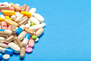Pills are scattered over a blue background