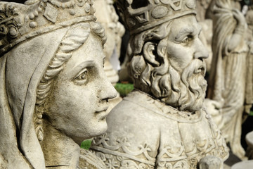 Garden ornaments in concrete showing face of a king and queen.