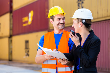 Worker and manager in logistics company discussing freight documents