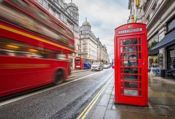 Foto op Canvas London, England - Iconic blurred vintage red double-decker bus on the move with traditional red telephone box in the center of London at daytime © zgphotography