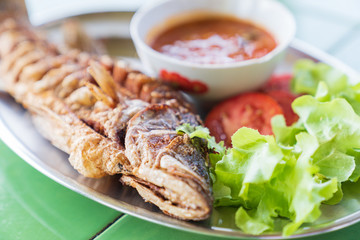 Fried fresh big fish with salad and hot spicy sauce.