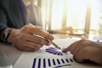 Business and partners discussing new plans marketing financial graph data on office table with...