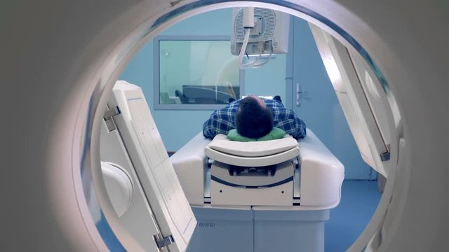 Medical examination concept. One man gets a tomographic scan in clinic.