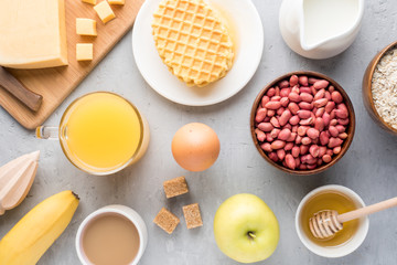 Healthy Breakfast Cheese Juice coffee Honey Peanuts Egg Biscuits Waffles Cereal Oatmeal Apple Banana. Selective focus. The view from the top. Flat position