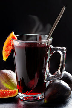 Hot figs tea and fresh figs in front of black background