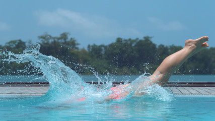 CLOSE UP: Active woman unwinds on exotic island by diving into luxury hotel pool