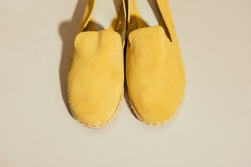 closeup view of yellow stylish espadrilles on beige background