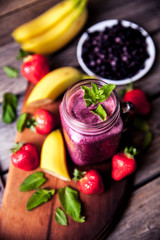 Blueberry smoothies on a wooden background with fruits. Vitamins