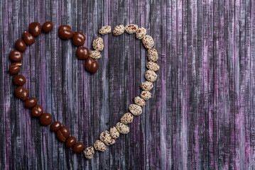 Peanuts in chocolate. Peanut with caramel and sesame seeds. Sweet peanut posted heart.