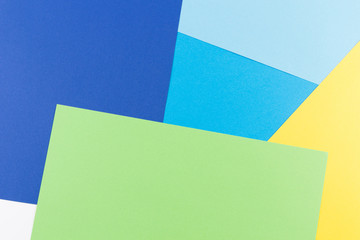 Color papers geometry flat composition background with yellow, green, white and blue tones