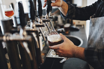 Bartender pouring beer from tap