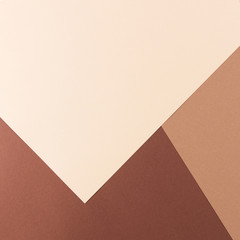 Color papers geometry composition background with pink, beige and brown tones.
