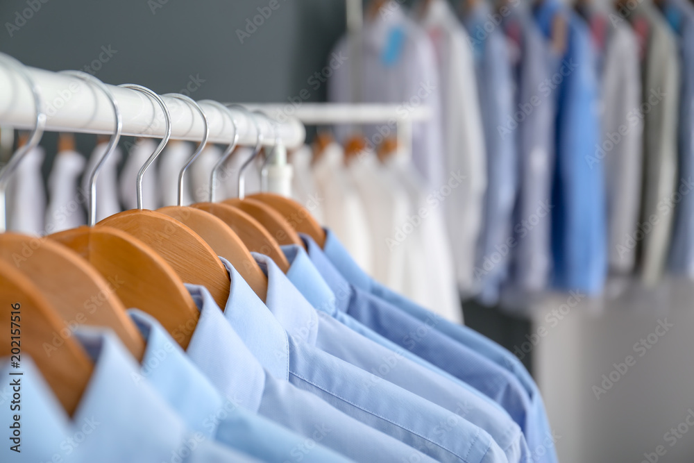 Wall mural Rack with clean clothes on hangers after dry-cleaning indoors