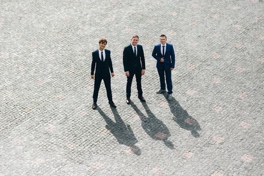 Look from above at groomsmen and groom waiting on the backyard for a bride