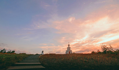 bride and groom walking on the sand at sunset